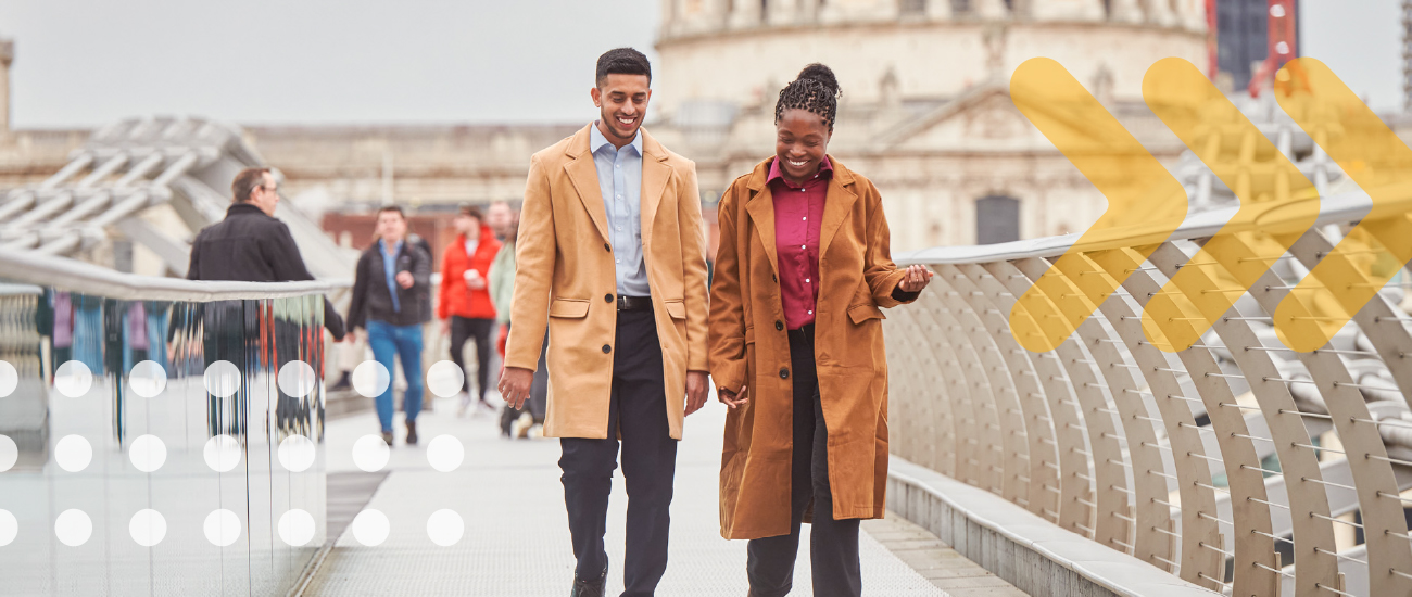 Two people talking while walking over bridge in London